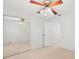 Bright bedroom with mirrored closet doors and ceiling fan at 9901 1St E St # D, Treasure Island, FL 33706