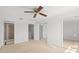 Bright bedroom with ceiling fan, mirrored closet doors, and view of the en-suite bathroom at 9901 1St E St # D, Treasure Island, FL 33706