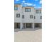 Contemporary townhome featuring gray trim, drive-under garages, and a paver driveway at 9901 1St E St # D, Treasure Island, FL 33706