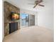 Bright living room featuring a stone fireplace, ceiling fan, and sliding doors to a waterfront view at 9901 1St E St # D, Treasure Island, FL 33706