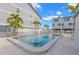 Community pool with palm trees and patio furniture, surrounded by well-maintained buildings at 9901 1St E St # D, Treasure Island, FL 33706
