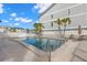 Community pool with palm trees and patio furniture, surrounded by well-maintained buildings at 9901 1St E St # D, Treasure Island, FL 33706