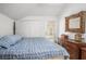 Comfortable bedroom featuring a blue and white bed, wooden dresser, closet, and outdoor access at 11101 Corlett Rd, Riverview, FL 33578
