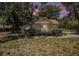 Charming single-story home featuring a cozy front porch surrounded by lush landscaping and mature trees at 11101 Corlett Rd, Riverview, FL 33578