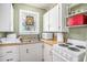 Well-lit kitchen with white cabinets, updated appliances, and a stained glass window bringing in bright light at 11101 Corlett Rd, Riverview, FL 33578