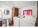Well-organized laundry room with modern washer and dryer units, storage, and natural light at 11101 Corlett Rd, Riverview, FL 33578