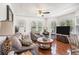Bright living room showcasing hardwood floors, comfortable seating, and plentiful natural lighting at 11101 Corlett Rd, Riverview, FL 33578