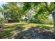 Grassy backyard featuring mature shade trees and privacy fence at 10137 Oleander Dr, Port Richey, FL 34668