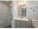 Bathroom with a glass-enclosed shower, a gray vanity with a sink, and a mirrored medicine cabinet at 10137 Oleander Dr, Port Richey, FL 34668