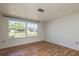 Bright bedroom featuring hardwood floors, white walls, and natural light from the window at 10137 Oleander Dr, Port Richey, FL 34668