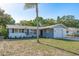 Charming single-story home with a well-maintained lawn, bright, white exterior, and mature trees at 10137 Oleander Dr, Port Richey, FL 34668