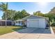 Single-story home featuring a white exterior, one-car garage, and palm tree in the front yard at 10137 Oleander Dr, Port Richey, FL 34668