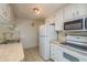 Bright kitchen with white cabinets, tile backsplash, stainless steel appliances, and tile flooring at 10137 Oleander Dr, Port Richey, FL 34668