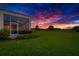 Backyard with a covered lanai, lush landscaping and scenic sunset views at 10509 Broadland Pass, Thonotosassa, FL 33592