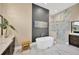 Modern bathroom with a soaking tub, shower, dual vanities, and stylish gray accent wall at 10509 Broadland Pass, Thonotosassa, FL 33592