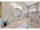 Modern bathroom featuring granite counters, a glass shower, and natural lighting at 10509 Broadland Pass, Thonotosassa, FL 33592