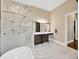 Bright bathroom featuring a marble-lined shower, marble floors, and a spacious vanity at 10509 Broadland Pass, Thonotosassa, FL 33592