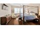 Spacious bedroom with hardwood floors, a four-poster bed, and a sitting area by the window at 10509 Broadland Pass, Thonotosassa, FL 33592