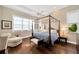 Bright bedroom with hardwood floors, four-poster bed, and natural light streaming through the windows at 10509 Broadland Pass, Thonotosassa, FL 33592