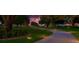 Long paved driveway winding through beautifully landscaped grounds at twilight at 10509 Broadland Pass, Thonotosassa, FL 33592