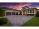 Stunning exterior with a three-car garage and meticulous landscaping at sunset at 10509 Broadland Pass, Thonotosassa, FL 33592