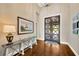 Bright foyer featuring elegant lighting, stylish console table and rich hardwood floors at 10509 Broadland Pass, Thonotosassa, FL 33592
