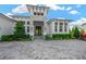 Gorgeous home exterior with a paved driveway, manicured shrubs, and large windows at 10509 Broadland Pass, Thonotosassa, FL 33592