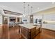 Open concept kitchen next to living room with large island, modern lighting, and hardwood floors at 10509 Broadland Pass, Thonotosassa, FL 33592