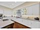 Well-lit kitchen featuring white cabinets, hardwood floors, and stainless steel appliances at 10509 Broadland Pass, Thonotosassa, FL 33592