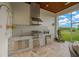 Covered outdoor kitchen with built-in grill and granite countertops at 10509 Broadland Pass, Thonotosassa, FL 33592