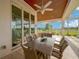 Covered patio with dining area with seating for six overlooking the yard at 10509 Broadland Pass, Thonotosassa, FL 33592