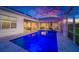 Backyard pool lit with blue lights inside screened enclosure at 10509 Broadland Pass, Thonotosassa, FL 33592