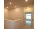 Upstairs hallway featuring neutral walls and carpet, leading to rooms with bright windows at 10708 Oak Bend Dr, Parrish, FL 34219
