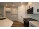 Well-lit kitchen featuring white cabinetry, stainless steel appliances, and a modern backsplash at 10708 Oak Bend Dr, Parrish, FL 34219