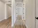 Hallway featuring light-toned floors leading to a bedroom with paneled doors at 11443 Apple Tree Cir, Bradenton, FL 34211