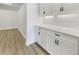Kitchen features white cabinetry with dark hardware and laminate floor at 11443 Apple Tree Cir, Bradenton, FL 34211