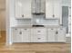 Bright kitchen features white cabinetry, subway tile backsplash, modern vent hood, and stainless steel appliances at 11443 Apple Tree Cir, Bradenton, FL 34211