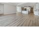 Expansive living area showcases wood floors and seamless transition to a modern kitchen with white cabinetry at 11443 Apple Tree Cir, Bradenton, FL 34211