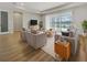 Bright living room featuring modern furniture, wood floors, and sliding glass doors with views of the pool at 11443 Apple Tree Cir, Bradenton, FL 34211