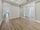 Open-concept living room with wood floors and view of the kitchen at 11443 Apple Tree Cir, Bradenton, FL 34211