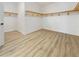 Spacious walk-in closet featuring wood-style flooring and built-in wooden shelving to keep you organized at 11443 Apple Tree Cir, Bradenton, FL 34211