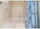 Bathroom featuring a white soaking tub, tiled walls, and shower with a decorative curtain for privacy at 11450 Harbor Way # 5008, Largo, FL 33774