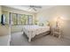 Bright bedroom featuring neutral carpet, ceiling fan, and a large window providing natural light at 11450 Harbor Way # 5008, Largo, FL 33774