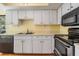 Kitchen featuring white cabinets, stainless steel appliances, and laminate flooring at 11450 Harbor Way # 5008, Largo, FL 33774