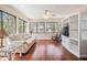 Bright living room with large windows, white couch, wood floors, and built-in shelving at 11450 Harbor Way # 5008, Largo, FL 33774