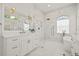 Bright bathroom featuring white marble walls and floors, a large glass shower, and gold fixtures at 1220 Darlington Oak Ne Cir, St Petersburg, FL 33703
