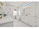 Bright bathroom featuring white marble walls and floors, a free-standing tub, and gold fixtures at 1220 Darlington Oak Ne Cir, St Petersburg, FL 33703