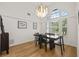 Elegant dining room featuring a modern chandelier, large windows, and stylish wood floors at 1220 Darlington Oak Ne Cir, St Petersburg, FL 33703