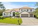 Attractive two-story home with a well-manicured lawn, three-car garage and mature landscaping at 1220 Darlington Oak Ne Cir, St Petersburg, FL 33703
