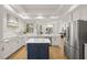 Elegant kitchen featuring stainless steel appliances, quartz countertops, an island, and white cabinetry with gold hardware at 1220 Darlington Oak Ne Cir, St Petersburg, FL 33703